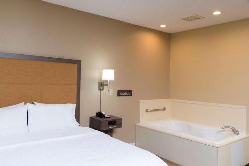 1 dormitorio con cama y bañera en Hampton Inn & Suites Mansfield South @ I 71, en Mansfield