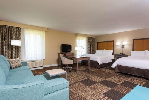 a hotel room with two beds and a couch at Hampton Inn & Suites Mansfield South @ I 71 in Mansfield