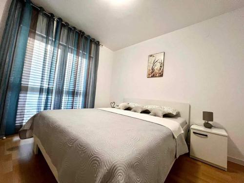 a bedroom with a large bed and a window at Apartments Possedaria in Posedarje