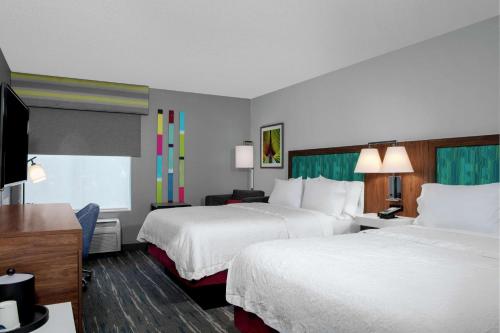 a hotel room with two beds and a flat screen tv at Hampton Inn Lake Buena Vista / Orlando in Orlando