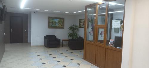 a waiting room with two chairs and a glass door at Квартира ЖК Милениум парк in Promyshlennyy
