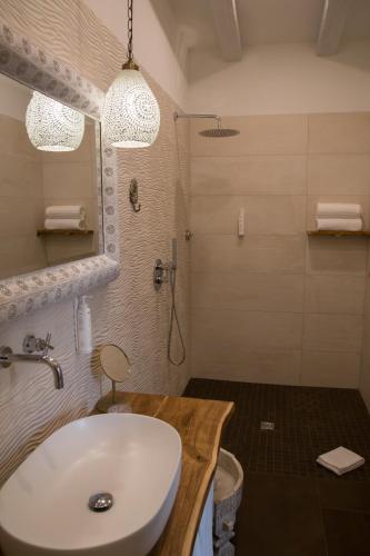 a bathroom with a white sink and a shower at Amelia Apts & Rooms in Alghero