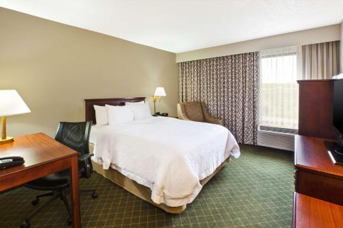 een hotelkamer met een bed en een bureau bij Hampton Inn Marietta in Marietta