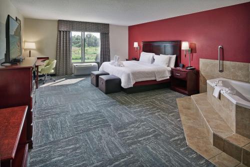a hotel room with a bed and a bathroom at Hampton Inn & Suites Millington in Millington