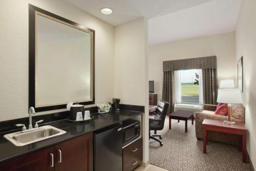 ein Badezimmer mit einem Waschbecken und ein Wohnzimmer in der Unterkunft Hampton Inn & Suites Millington in Millington