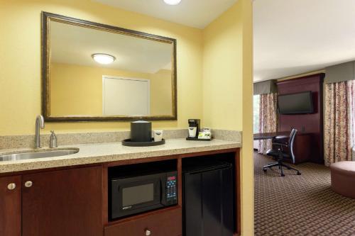 um quarto de hotel com um lavatório e um espelho em Hampton Inn & Suites Prattville em Prattville