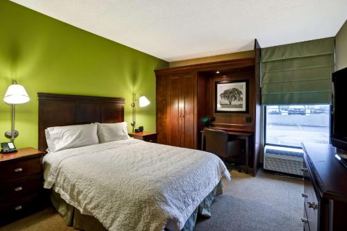 um quarto com uma cama, uma secretária e uma televisão em Hampton Inn Morgantown em Morgantown