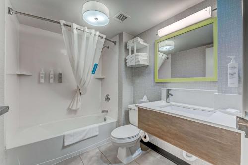 a bathroom with a tub and a toilet and a sink at Hampton Inn Morgantown in Morgantown