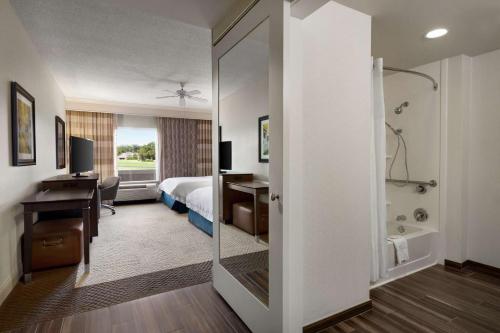 a hotel room with a bed and a desk and a bathroom at Hampton Inn & Suites Montgomery-EastChase in Montgomery