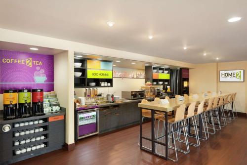 a restaurant with a bar with a table and chairs at Home2 Suites by Hilton Florida City in Florida City