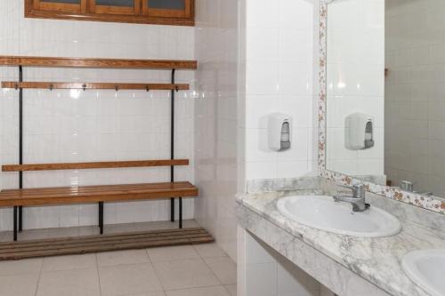 a bathroom with two sinks and a mirror at Apartamentos Bon Amb in Faro de Cullera