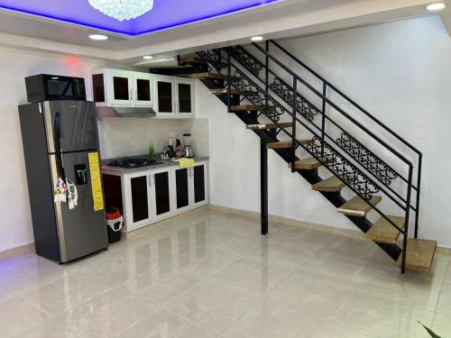 a spiral staircase in a kitchen with a refrigerator at Alojamiento paulino in Santiago de los Caballeros