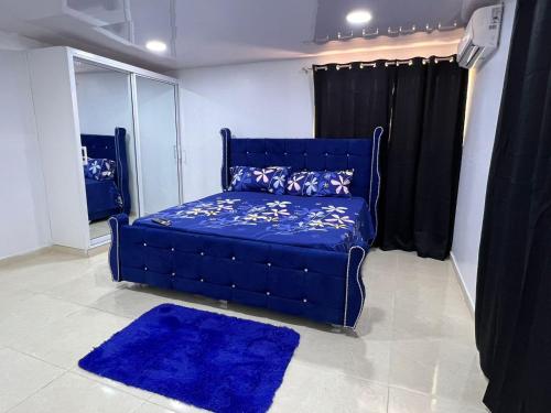 Sofá azul en la sala de estar con alfombra azul en Alojamiento paulino, en Santiago de los Caballeros