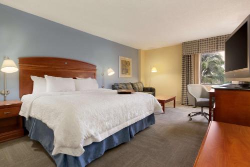 a hotel room with a bed and a desk at Hampton Inn Miami-Airport West in Miami