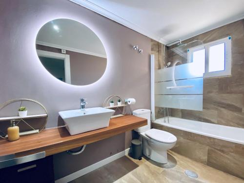 uma casa de banho com um lavatório, um WC e um espelho. em Casa Natura Sunset Beach em Gran Alacant