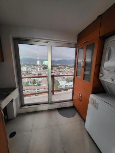a kitchen with a large window with a view of a city at DELUXE APARTMENT PUERTO VALLARTA in Puerto Vallarta