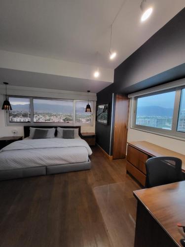 a bedroom with a bed and a large window at DELUXE APARTMENT PUERTO VALLARTA in Puerto Vallarta