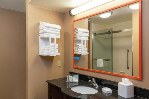 a bathroom with a sink and a mirror and towels at Hampton Inn & Suites Marshalltown in Marshalltown