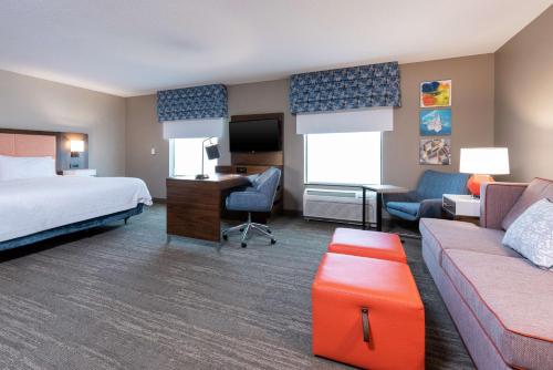 マーシャルタウンにあるHampton Inn & Suites Marshalltownのベッド、ソファ、デスクが備わるホテルルームです。