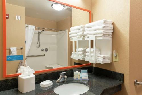 a bathroom with a sink and a mirror and towels at Hampton Inn & Suites Marshalltown in Marshalltown