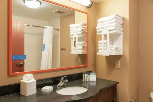 a bathroom with a sink and a mirror and towels at Hampton Inn & Suites Marshalltown in Marshalltown