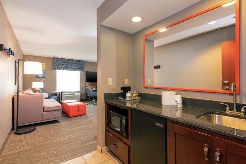 a bathroom with a sink and a living room at Hampton Inn & Suites Marshalltown in Marshalltown