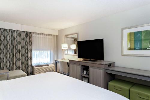 a hotel room with a bed and a flat screen tv at Hampton Inn Melbourne in Melbourne