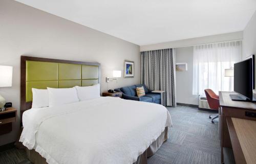 una camera d'albergo con un grande letto e una TV di Hampton Inn Middletown a Middletown