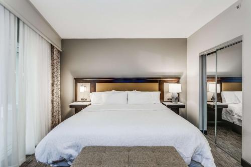 a bedroom with a large white bed and a window at Hampton Inn & Suites Mobile - Downtown Historic District in Mobile