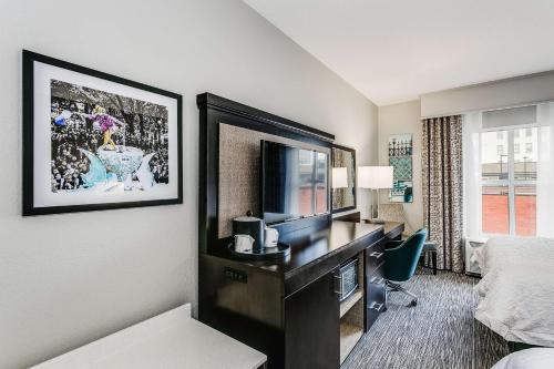 a hotel room with a desk with a television and a bed at Hampton Inn & Suites Mobile - Downtown Historic District in Mobile