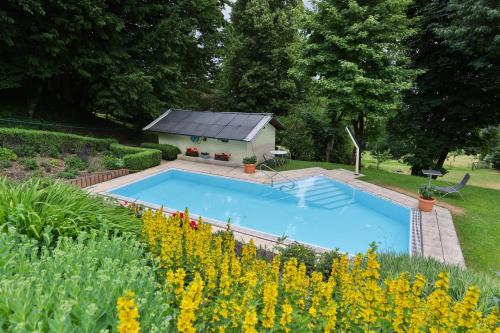 a swimming pool in the middle of a garden at Kurhaus Dr. Petershofer in Wolfsegg am Hausruck