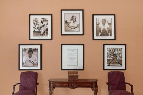 a wall with pictures on it with a table and chairs at Homewood Suites by Hilton Mobile Airport-University Area in Mobile
