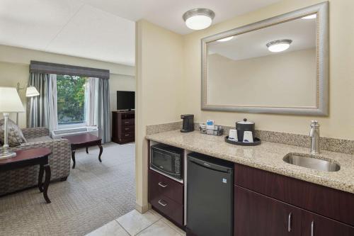 ein Hotelzimmer mit einem Waschbecken und einem Wohnzimmer in der Unterkunft Hampton Inn Fairhope-Mobile Bay, AL in Fairhope