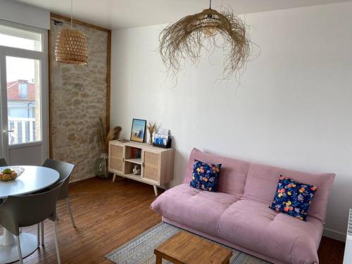 a living room with a pink couch and a table at Appartement, Royan. Proche plage. in Royan