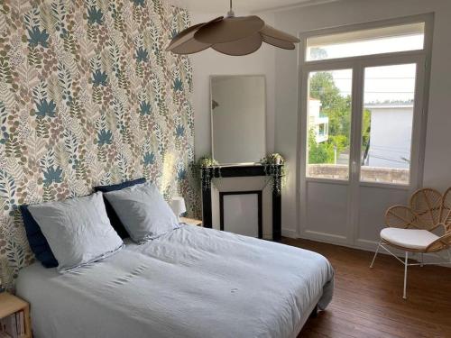 a bedroom with a bed and a fireplace and a window at Appartement, Royan. Proche plage. in Royan
