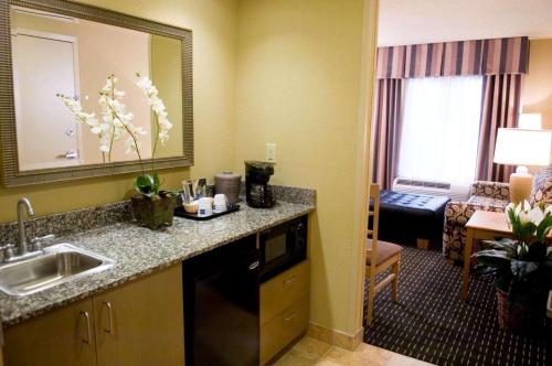 um quarto de hotel com uma cozinha e uma sala de estar em Hampton Inn & Suites Mobile Providence Park/Airport em Mobile