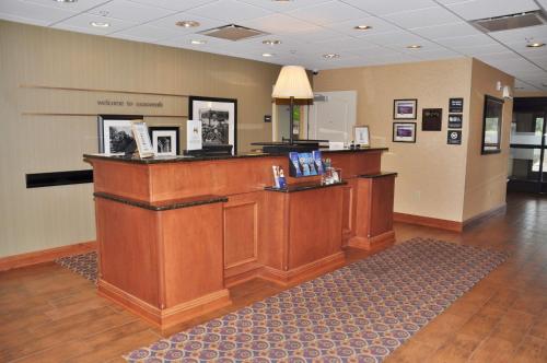 a lobby with a large wooden counter in a room at Hampton Inn Macomb in Macomb