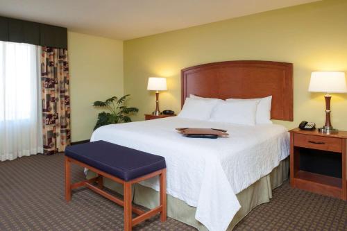 a hotel room with a large bed and a chair at Hampton Inn Macomb in Macomb