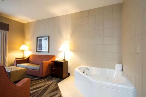 Habitación de hotel con bañera y sofá en Hampton Inn Marshall, en Marshall