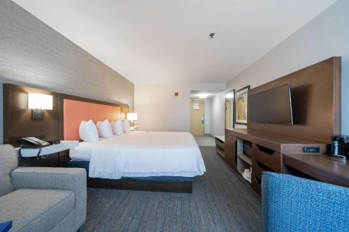 um quarto de hotel com uma cama e uma televisão em Hampton Inn & Suites Modesto - Salida em Modesto