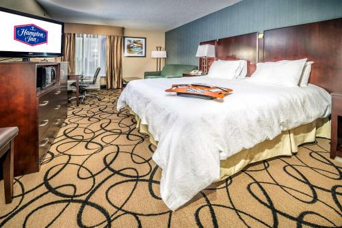 a hotel room with a large bed and a television at Hampton Inn Monroe in Monroe