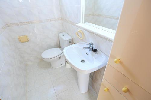 uma casa de banho branca com um WC e um lavatório em Edificio Isabel ONLY FAMILIES em Cambrils