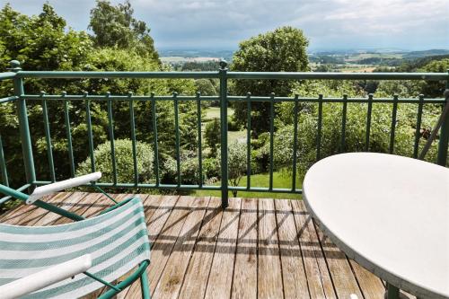 a balcony with a table and chairs and a view at Kurhaus Dr. Petershofer in Wolfsegg am Hausruck