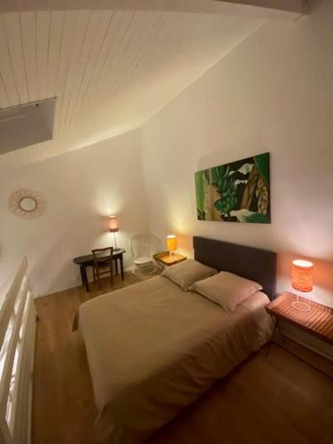 - une chambre avec un lit et deux lampes sur les tables dans l'établissement - Appartement Cauris -, à Vieux-Boucau-les-Bains