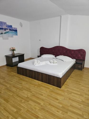 a large bed in a room with a wooden floor at Casa Beatrice in Eşelniţa