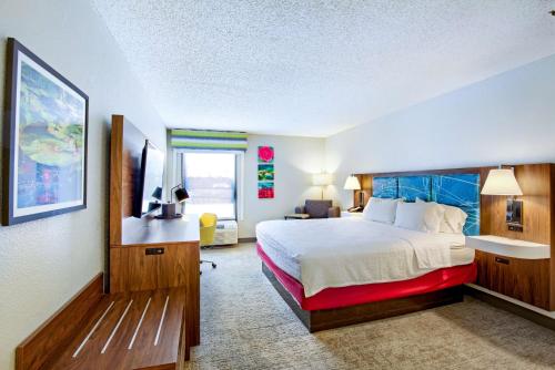 a hotel room with a bed and a flat screen tv at Hampton Inn Slidell in Slidell