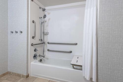 a bathroom with a shower and a white bath tub at Hampton Inn & Suites Minneapolis St. Paul Airport - Mall of America in Bloomington