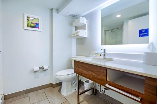 ein Badezimmer mit einem Waschbecken, einem WC und einem Spiegel in der Unterkunft Hampton Inn Slidell in Slidell