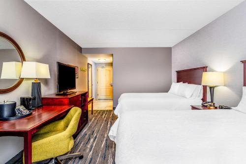 a hotel room with two beds and a desk and a television at Hampton Inn & Suites Minneapolis St. Paul Airport - Mall of America in Bloomington