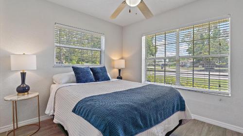 - une chambre avec un lit doté d'oreillers bleus et 2 fenêtres dans l'établissement Paradise Palace, à Sarasota